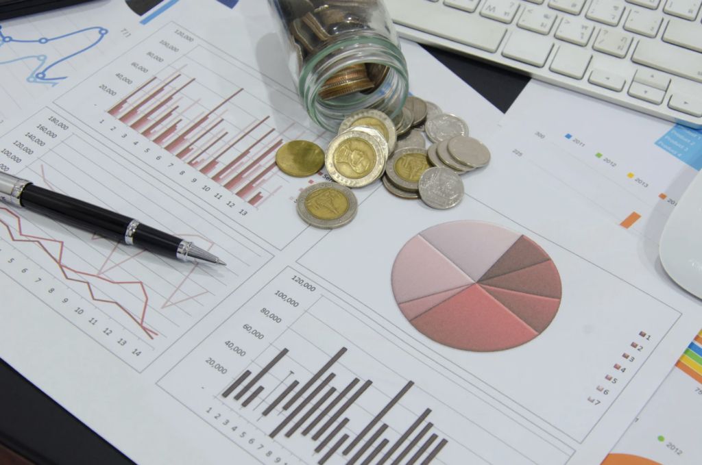 Graphiques financiers avec des pièces en euros symbolisant l'analyse des budgets, des marges bancaires et des impacts économiques sur les collectivités locales